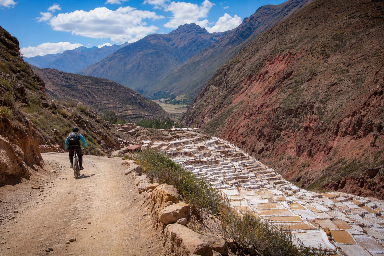 Mountain biker on a dirt track above the Salineras de Maras salt mines in the Sacred Valley