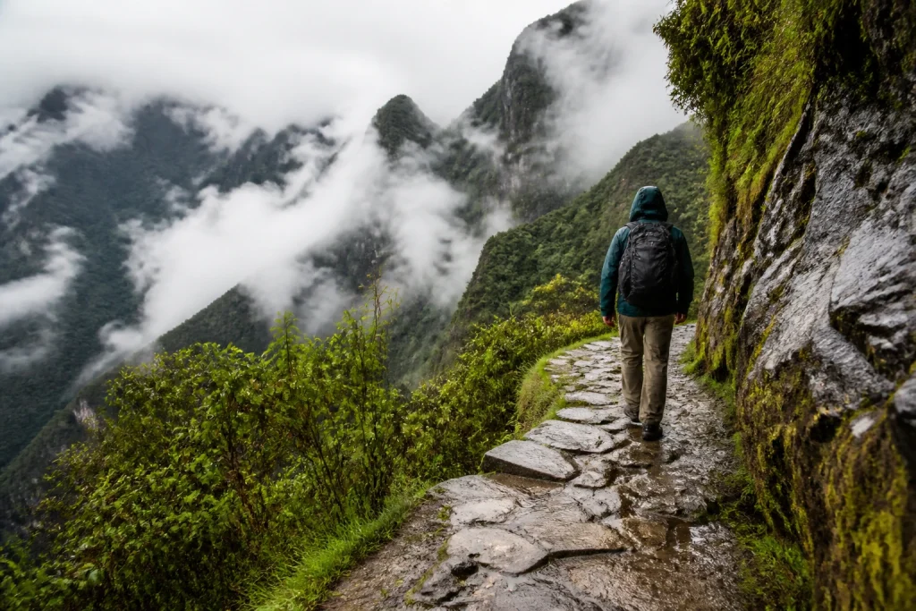 A wet Inca Trail path in the Historic Sanctuary of Machupicchu during rainy conditions.