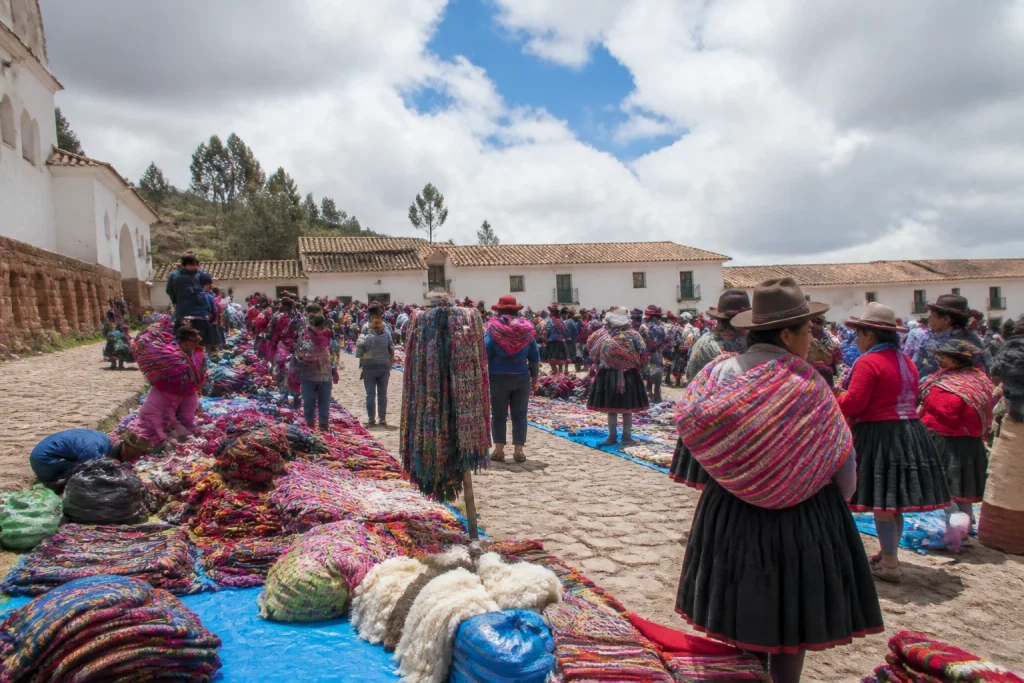 Textile stalls and visitors at the Chinchero Sunday market