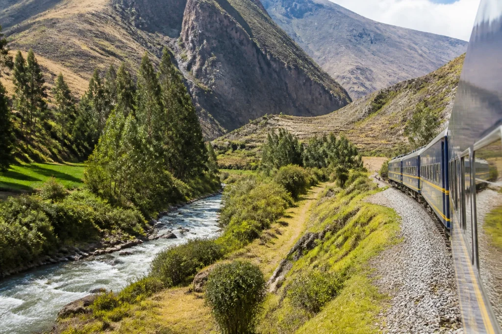 Passenger train traveling through the Andean landscape near Ollantaytambo