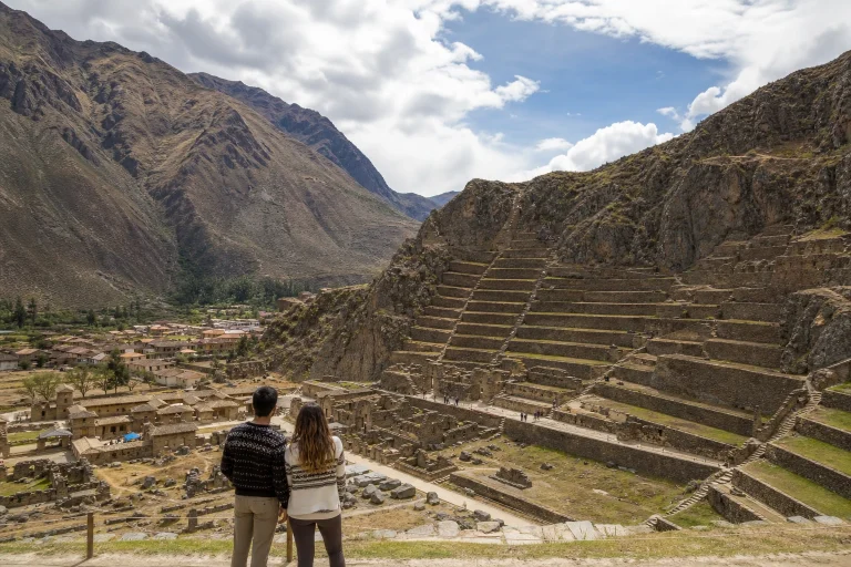Couple overlooking the stone terraces and mountains at Ollantaytambo Archaeological Park in the Sacred Valley