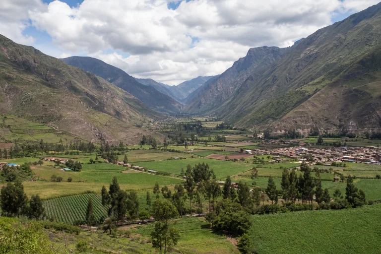 Wide view of the Sacred Valley in Peru surrounded by Andean mountains.